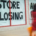 High Street 'Store Closing' sign with motion blurred shopper walking past. retail stocks